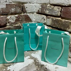 Set of three original Tiffany & Co blue bags and white ribbons.